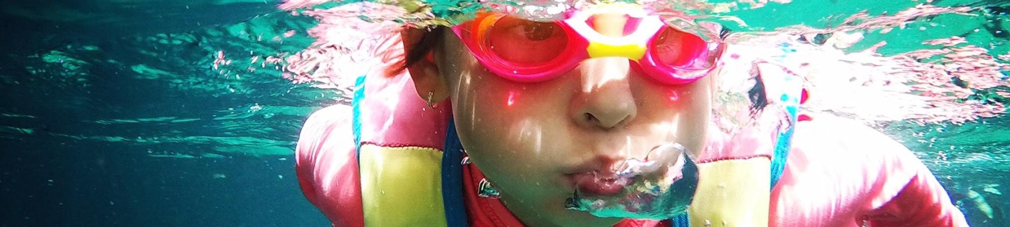 Kids swimming underwater with goggles on